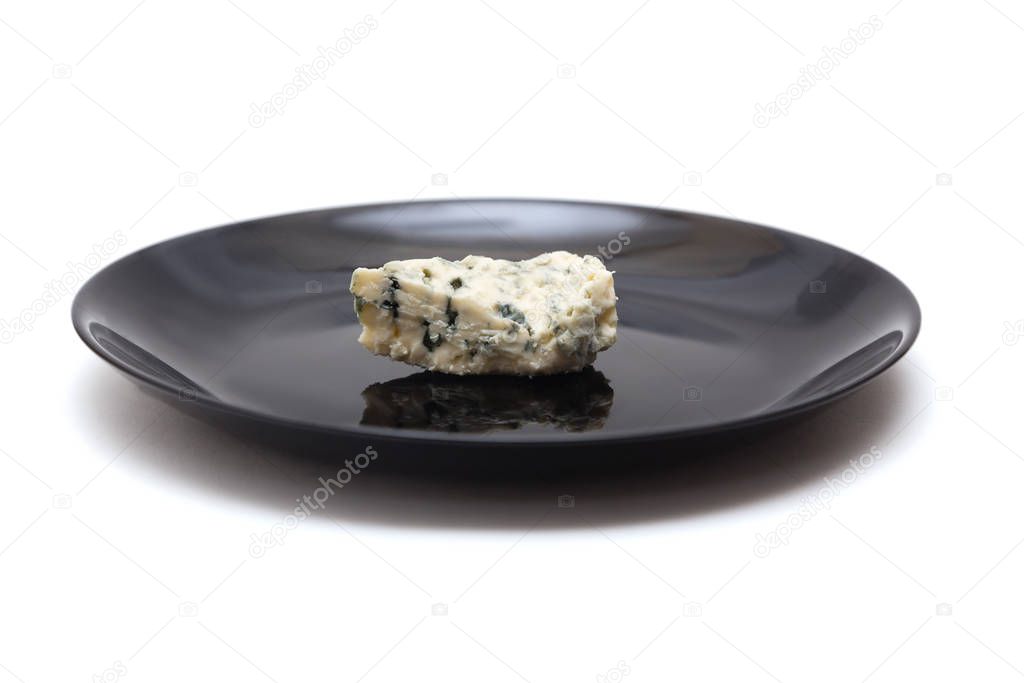 Piece of blue cheese with mold on black plate