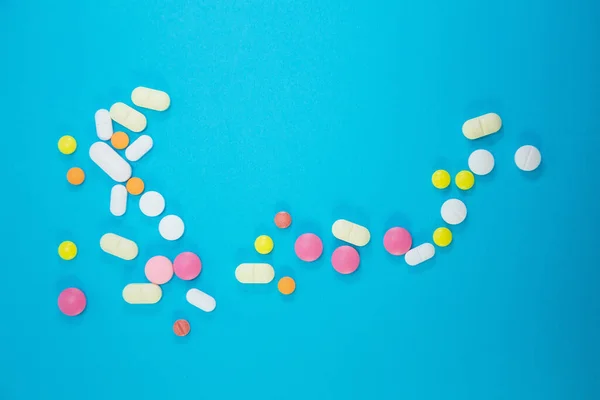 Szórása orvosi színes tabletták kék háttér — Stock Fotó