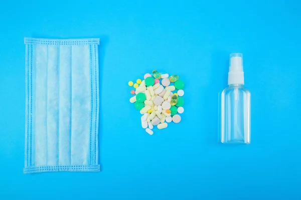 Hygienische Gesichtsmaske, Medikamente, Alkohol-Gel-Sanitizer Handgelreiniger gegen Bakterien und Viren auf blauem Hintergrund — Stockfoto