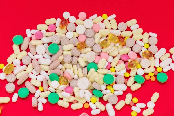 Medizinische Pillen auf rotem Hintergrund. Ansicht von oben. Medizinkonzept — Stockfoto