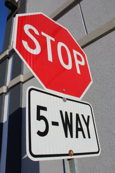 Vijf manier stopbord naast gebouw — Stockfoto