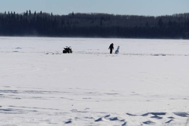 Donmuş bir gölün ortasında yalnız bir kardan adam kontrol