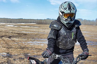 Closeup of a muddy boy in bike protection gear clipart