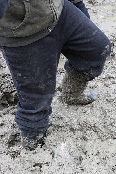 Primer plano de un niño caminando en barro grueso — Foto de Stock