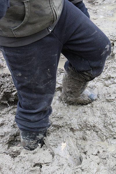 Closeup of a child walking in thick mud