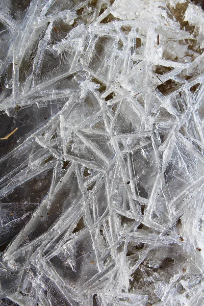 Agujas de hielo formadas en el borde del agua corriente con un fondo negro — Foto de Stock