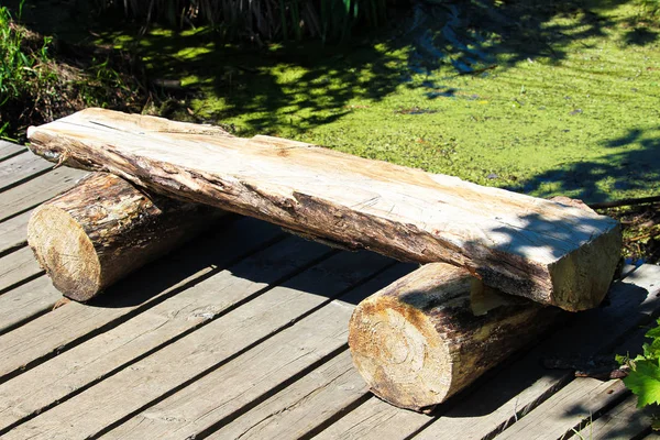 Una panca di legno tronco spaccato su un sentiero boardwalk — Foto Stock