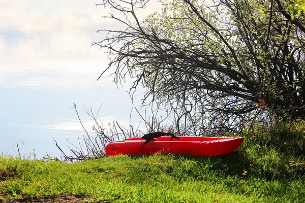 Un petit kayak d'enfant tiré vers le haut sur le bord du lac — Photo