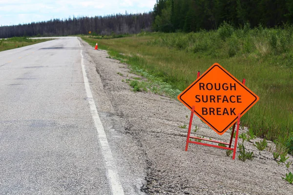 An orange rough surface break sign with a road into the distance — Stock Photo, Image