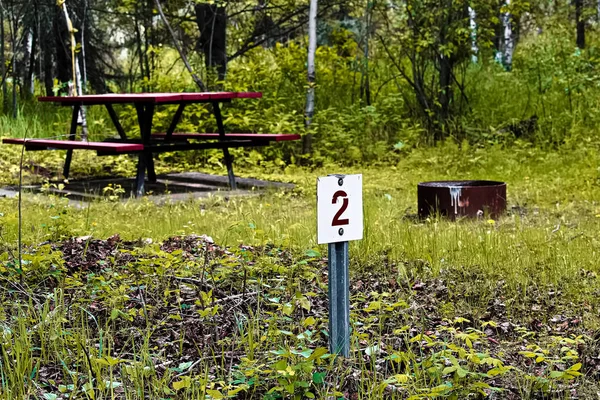 Numéro 2 auto-inscription marqueur de camping avec une table de pique-nique et foyer en arrière-plan — Photo