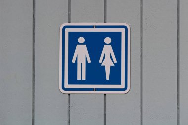 A blue male and female restroom sign clipart