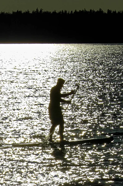 Zbliżenie sylwetki człowieka Wiosłowanie na jeziorze Saskatchewan — Zdjęcie stockowe