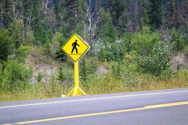 A pedestrian crossing sign on a highway