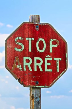 Mavi gökyüzüne karşı hem Fransızca hem de İngilizce'de eski bir dur işareti
