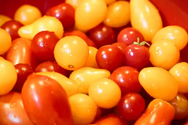 Closeup de tomates cereja em uma tigela vermelha — Fotografia de Stock