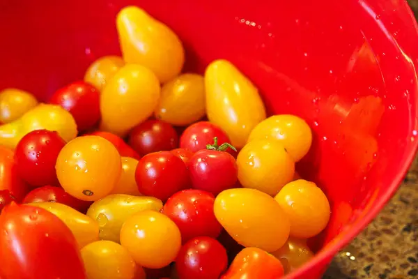 Closeup de tomates cereja em uma tigela vermelha — Fotografia de Stock