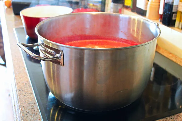 Una olla de salsa de tomate reduciendo en la estufa — Foto de Stock