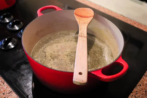 Una cuchara descansando encima de una olla con sopa hirviendo en ella — Foto de Stock