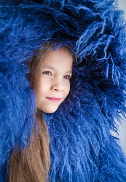 Retrato de uma menina envolta em um casaco de pele de uma longa pele azul — Fotografia de Stock