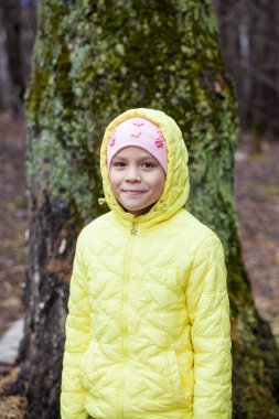 Bir kız bir bahar ormandaki bir sarı ceketli