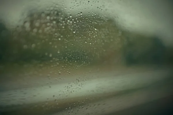 Gouttes de pluie le jour de pluie sur vitre extérieure avec bordure floue — Photo