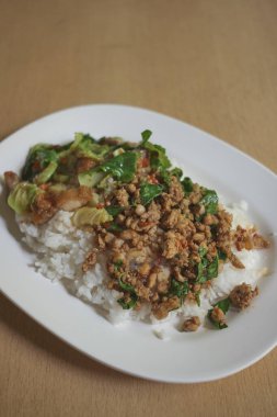 Pirinç kıymalı domuz eti ve fesleğen yaprağıyla kaplanmış. Tayland sokak yemeği..