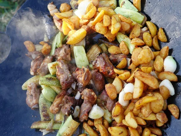 Жареные овощи, картофель и мясо в большой сковороде . — стоковое фото