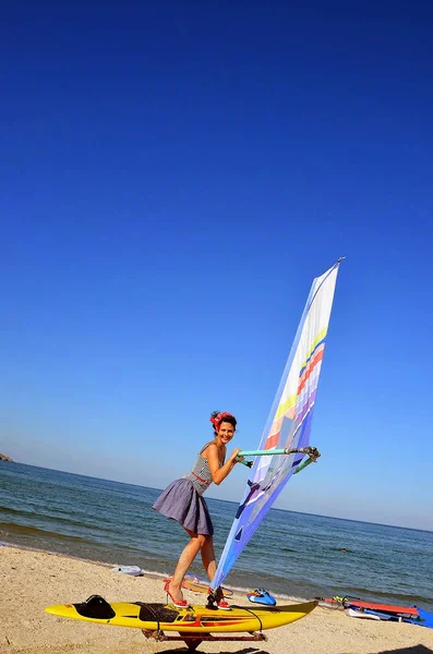 Dziewczyna w szkole windsurfingu uczy się jeździć desek windsurfingowych. — Zdjęcie stockowe