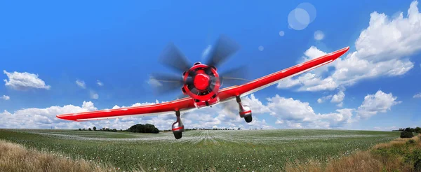 An athletic light-engine aircraft flies over the field. Aviation in agriculture. Adrenaline, the concept of travel.