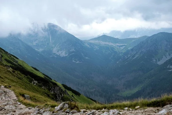 Un sentiero di montagna. Cime di montagne tra le nuvole . — Foto Stock