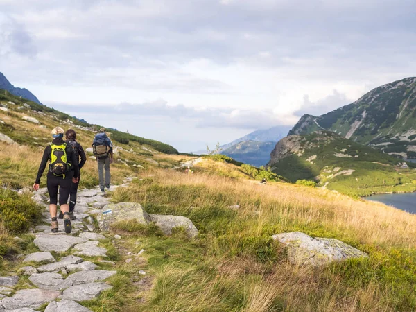 Dağlarda yolda insanlar sırt çantaları ile gider.