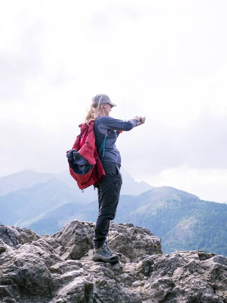 Una mujer en la cima de la montaña toma fotos en un teléfono inteligente — Foto de Stock