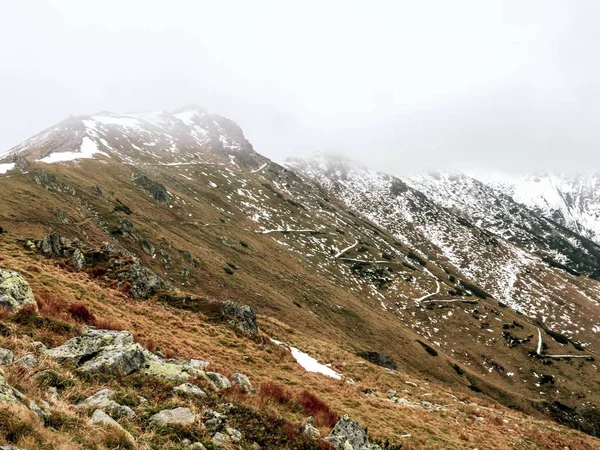 Herfst in de bergen, sneeuw op de toppen, pieken in de wolken — Stockfoto