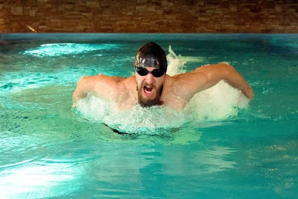 Un nadador con barba, gafas y gorra para nadar en la piscina —  Fotos de Stock