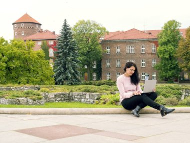 Arsa üzerinde bir dizüstü bilgisayar ile kız