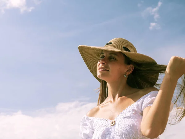 Dívka v klobouku na pozadí oblohy — Stock fotografie