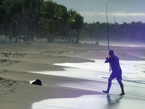 Pescador com fiação na praia — Fotografia de Stock
