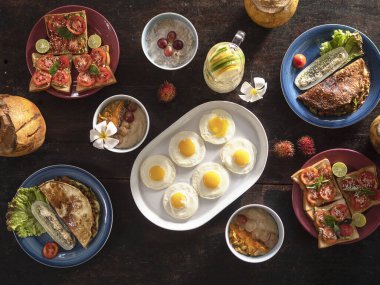 Kahvaltınız karanlık masada. Yukarıdan bak. Geleneksel Avrupa yemekleri ile tropik çiçekler ve meyveler. Otel, dinlenme, tatil.