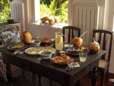 Bahçeye bakan antika bir masada kahvaltı. Yumurta, tost, limonata, hindistan cevizi..