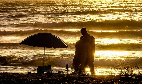 Man knuffelt een vrouw op het strand Rechtenvrije Stockfoto's