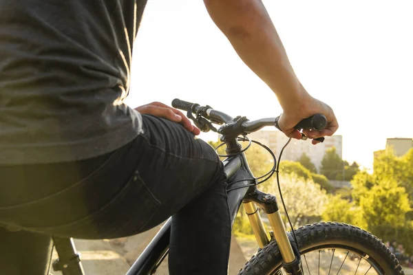 Detail of a man sitting on a mountain bicycle holding a handlebar grip at sunny summer day. — Stock Photo, Image