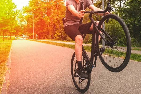 人骑自行车在路上。骑自行车在后轮上. — 图库照片