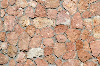 Doku kahverengi tonlarında. Doğal doğal taş granit ve kumtaşı yapılmış duvar