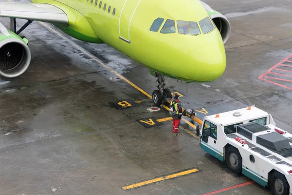 Reboque a aeronave da pista para o estacionamento com a ajuda de equipamento especial . — Fotografia de Stock