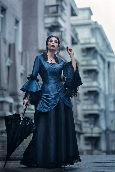Женщина в синем возле старого здания — стоковое фото