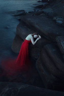 Akşam deniz kenarında üzgün bir kadın