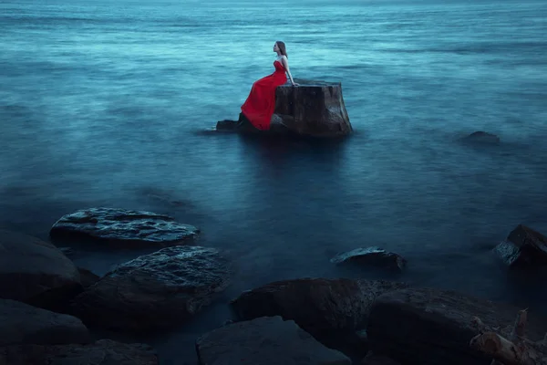 Eine traurige Frau am Abend am Meer — Stockfoto