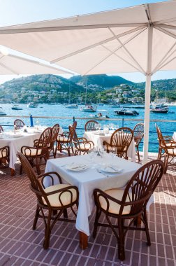 İspanyol bir restaurant, Akdeniz resort akşam yemeği. Rahat kaldırım kafe masaları Deniz Manzaralı şemsiye altında