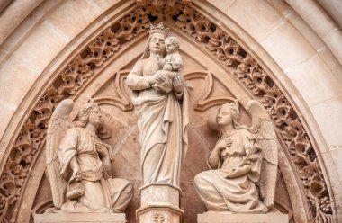 Bakire melekler tarafından çevrili bir çocuk taşıyan Maria heykel. Catedral de Santa Maria de Palma de Mallorca, turistik Majorca Adası'nın biri yan duvarına Portal.