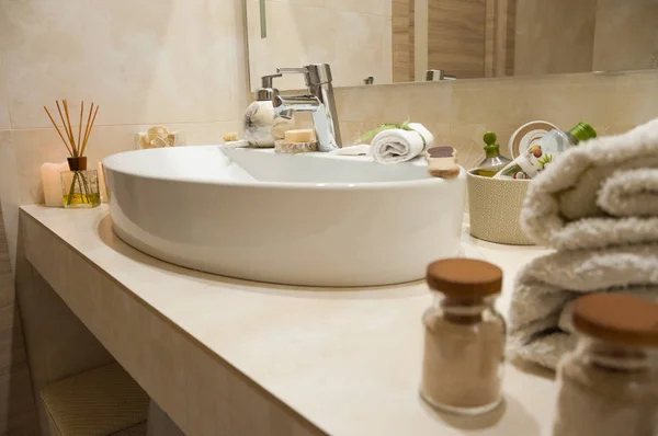 Bathroom interior with composition of spa treatment with towels, candles and other accessories. White porcelain sink in luxury bathroom. — Stock Photo, Image